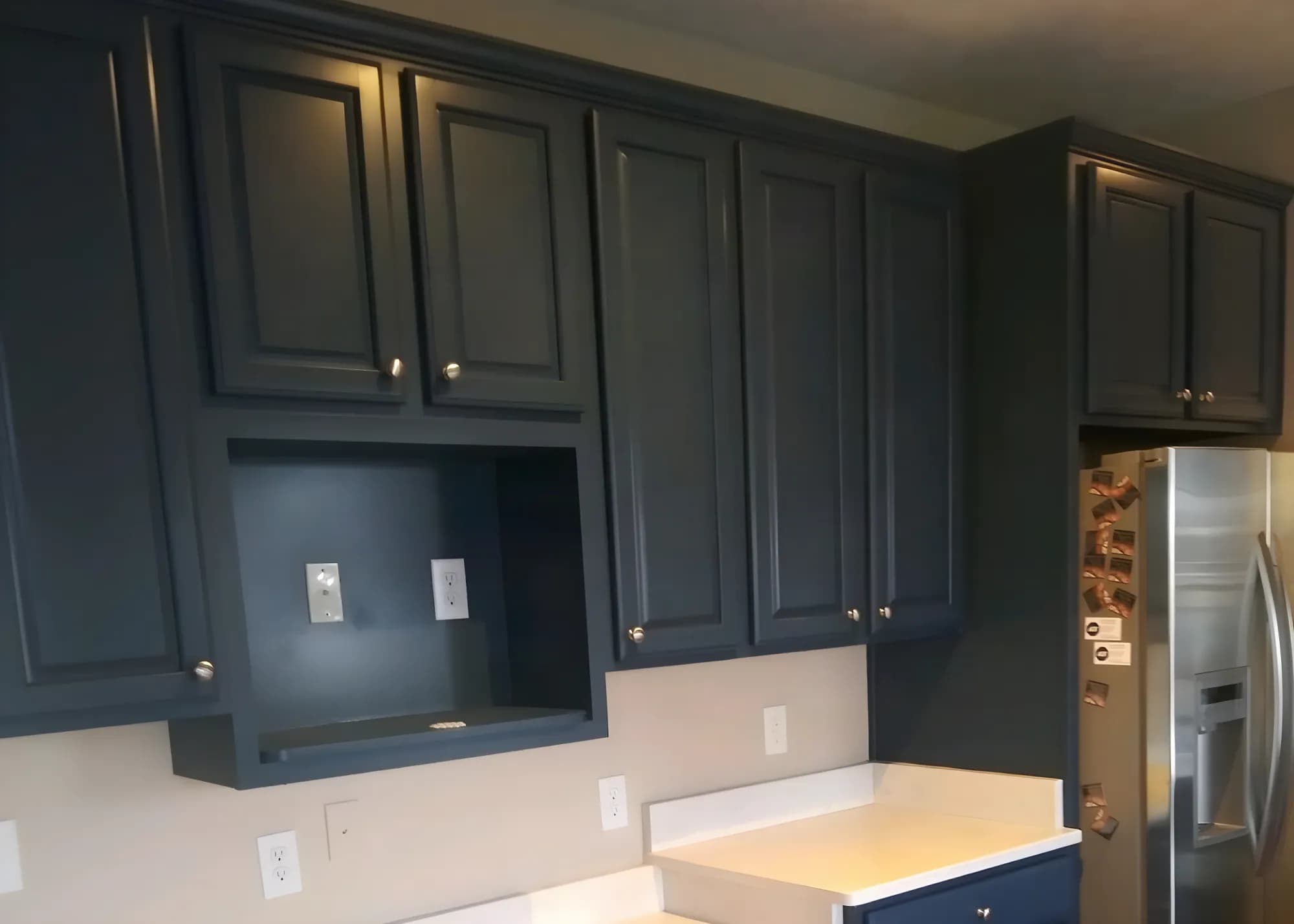 Upper kitchen cabinets painted navy by ALL IN Painting