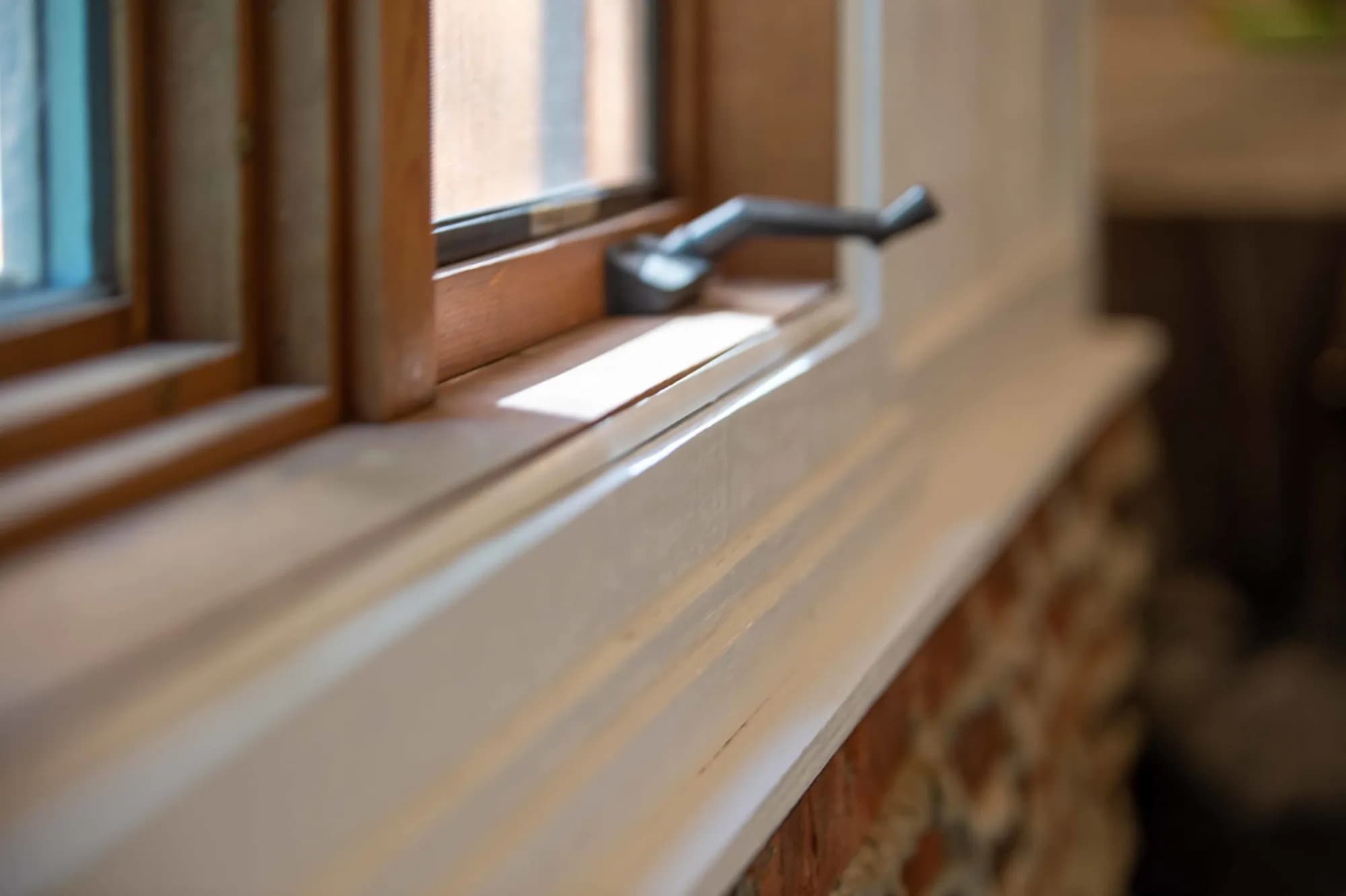 A window casing stained and the sill painted white by ALL IN Painting