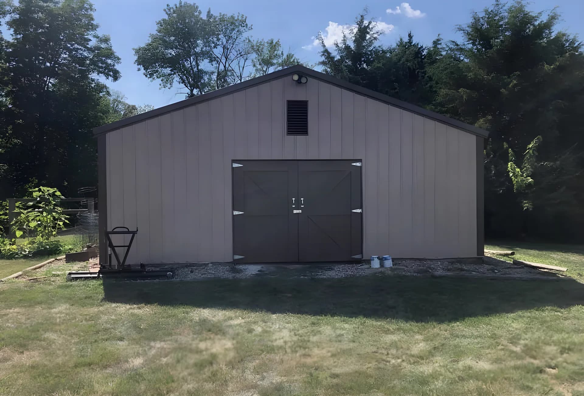 A pole barn repainted tan with dark doors by ALL IN Painting